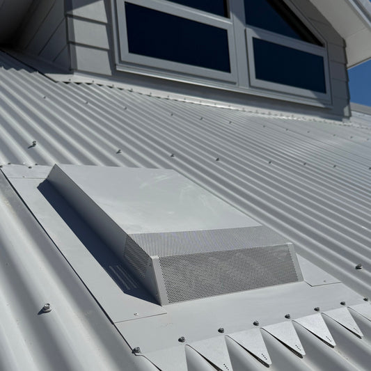 A low profile range hood roof vent installed on a corrugated metal roof.