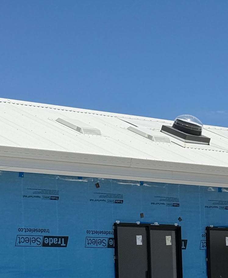 Two Dragon Vents Australia DV350LP low-profile roof vents installed beside a dome skylight on a white metal roof of a modular-style building.