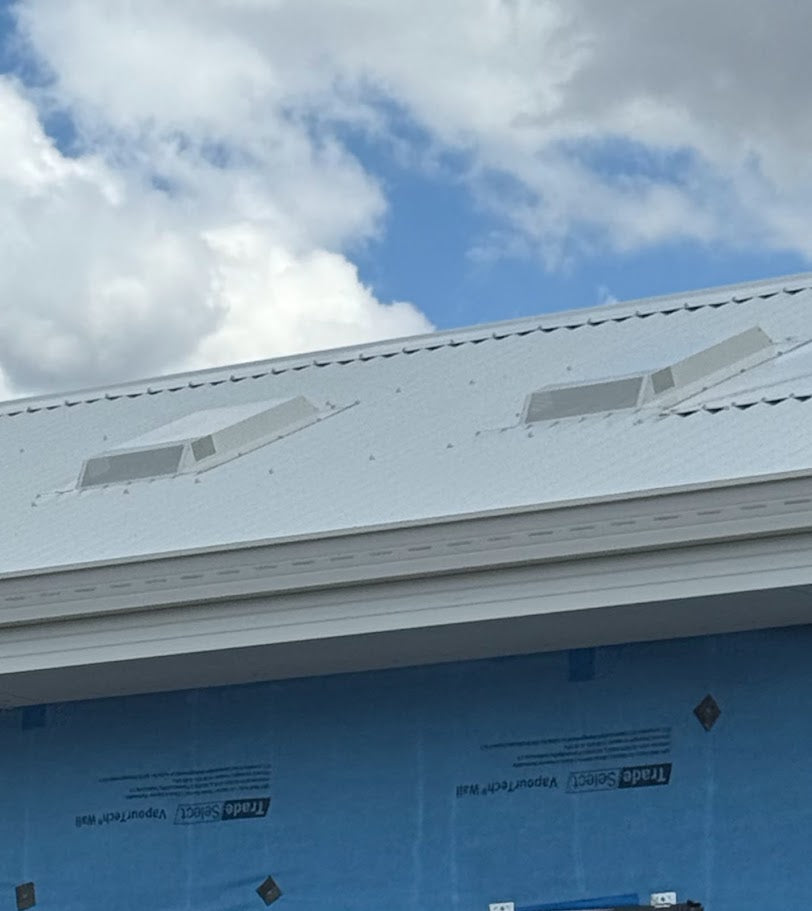 Two Dragon Vents Australia DV350LP low-profile rangehood roof vents installed on a white corrugated metal roof of a modular-style building under construction.
