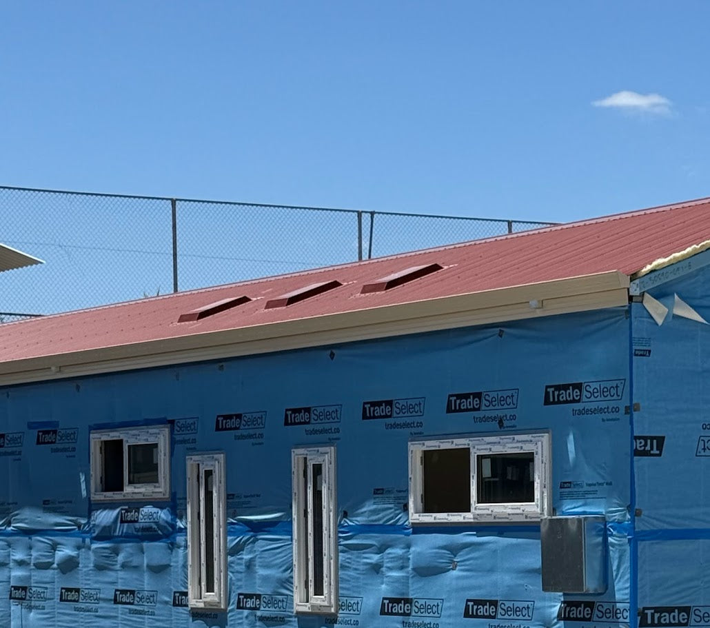 Three Dragon Vents Australia DV350LP low-profile roof vents installed on a red metal roof of a modular-style home under construction.